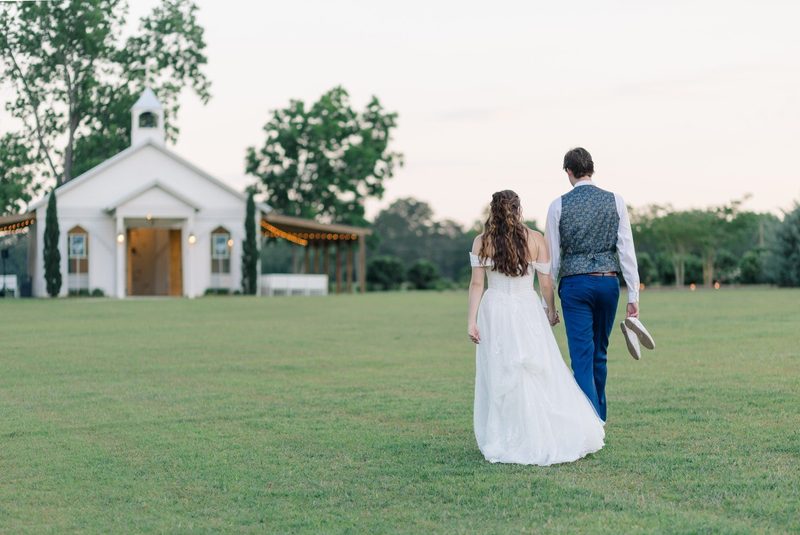 Couple walk toward a small white chapel