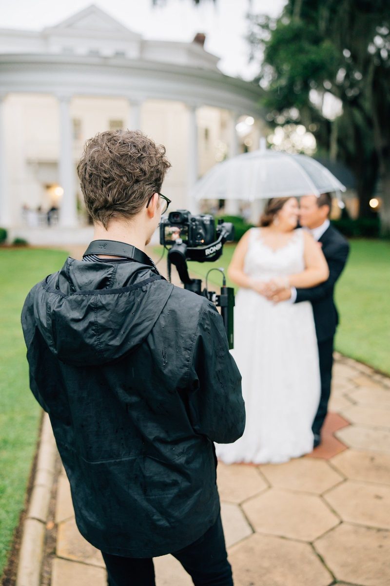 Behind the scenes: filming a couple under an umbrella outside a historic home
