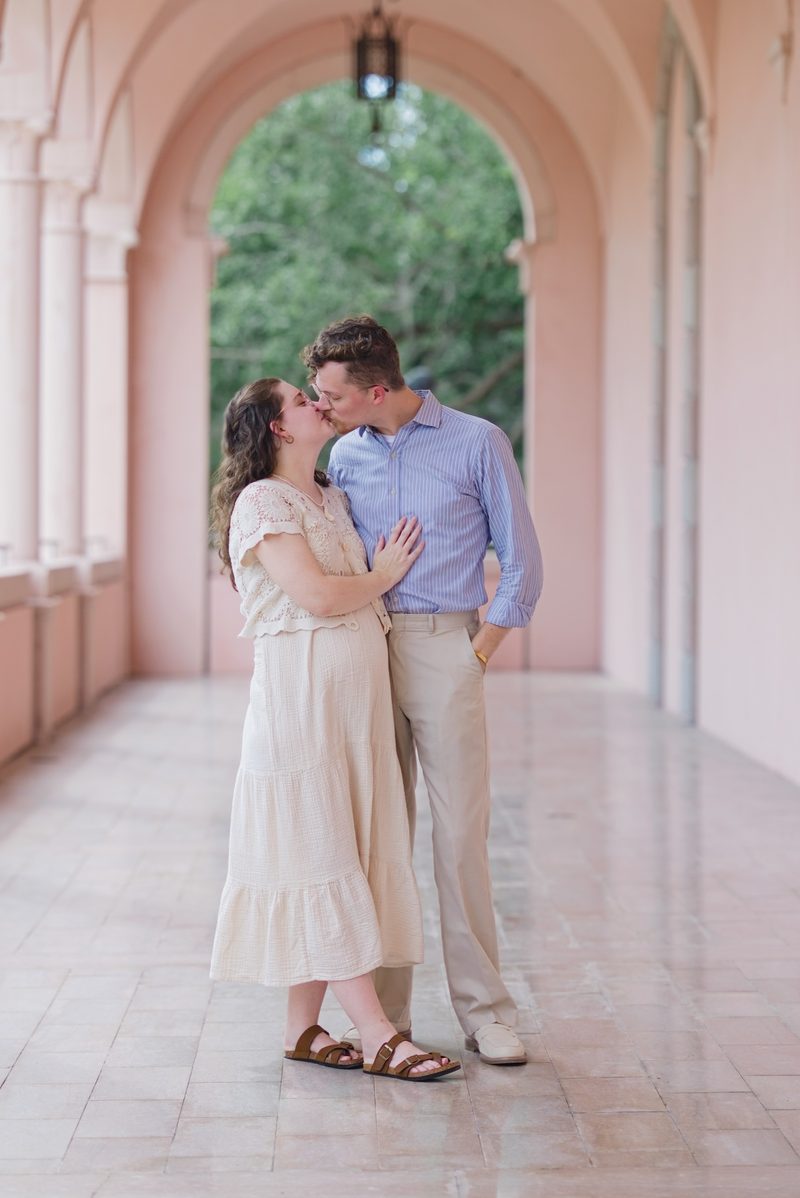 Grant and Morgan share a kiss in a pink arcade
