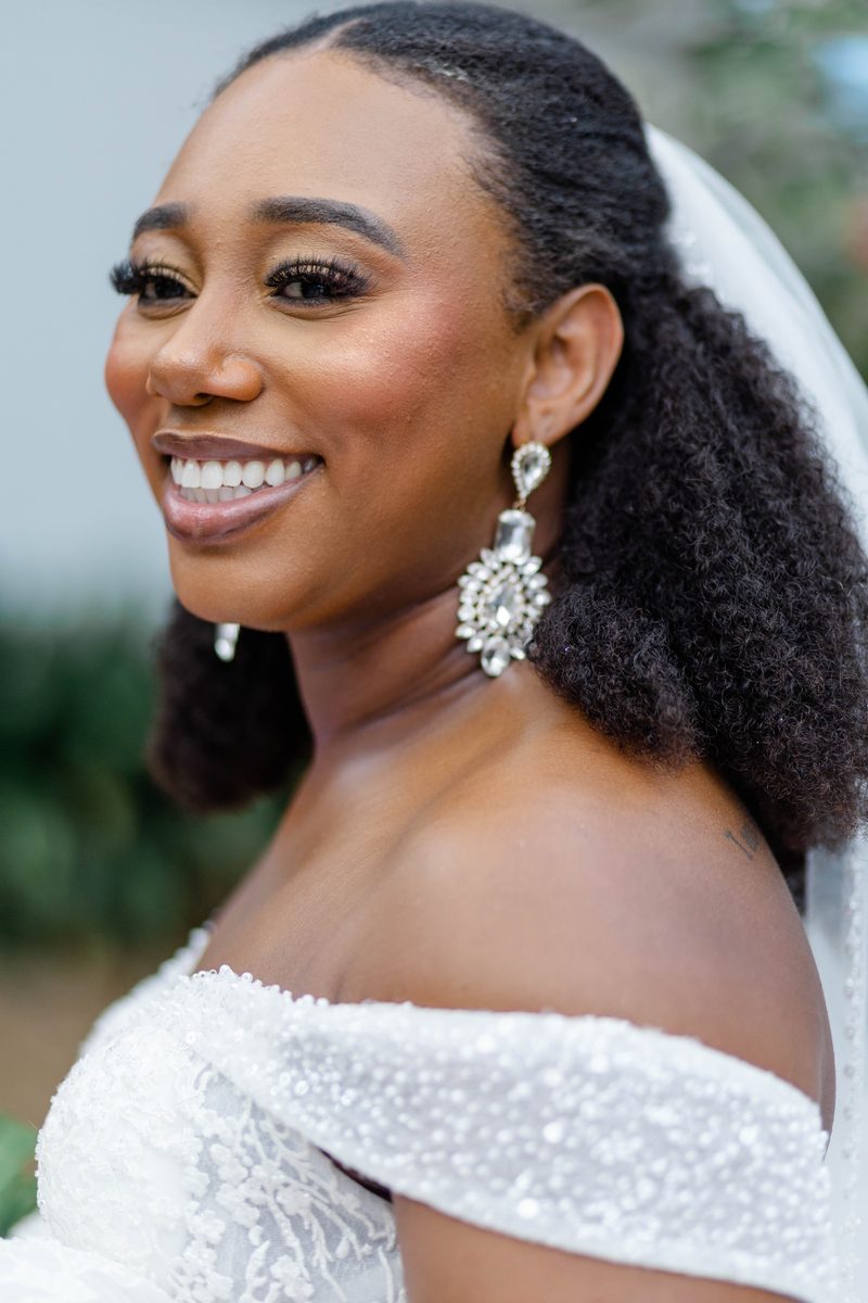 Bride smiling over her shoulder in an off-the-shoulder gown