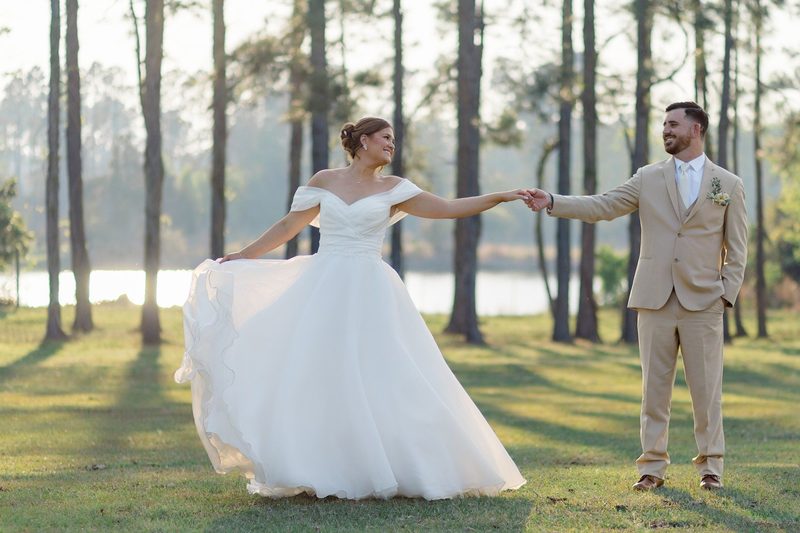 Bride twirls toward the groom among tall pines