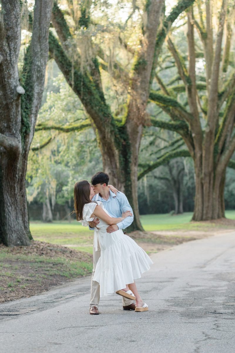 Couple kiss on a road beneath a canopy of live oaks