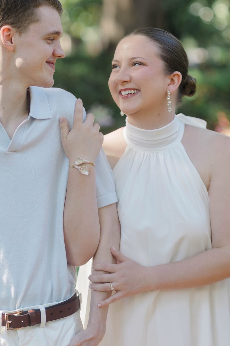 Couple laugh arm in arm beneath a tree in soft light